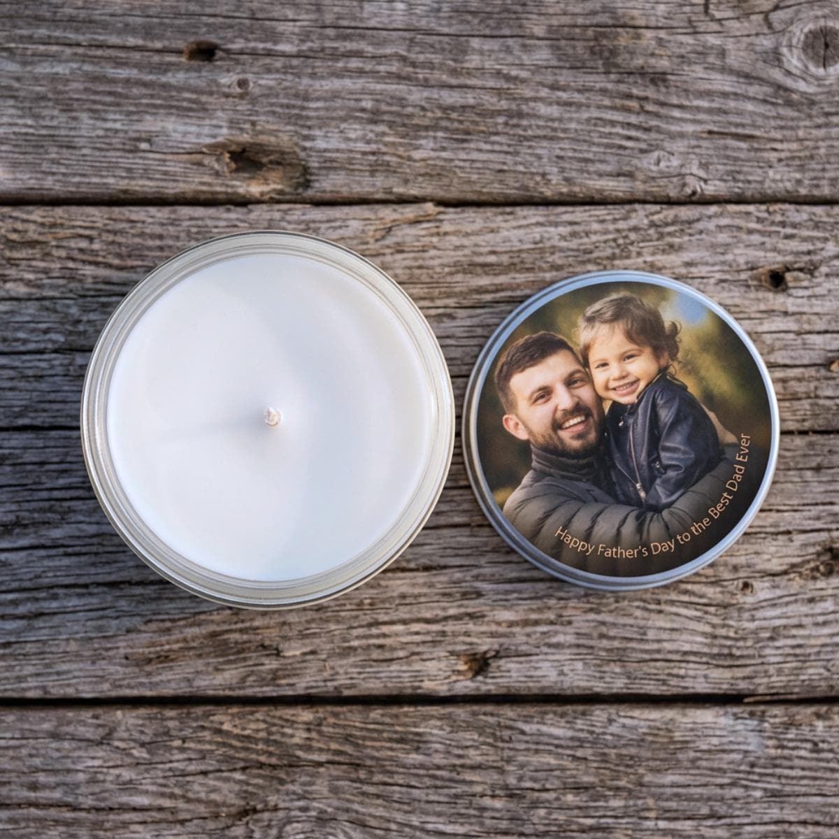 personalised candle shown open on rustic wooden boards, with natural wax and cotton wick visible and the printed photo lid resting alongside.