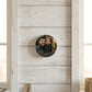 Personalised photo candle lid displayed on a white panelled wall, showing how the printed lid doubles as a keepsake photo display.