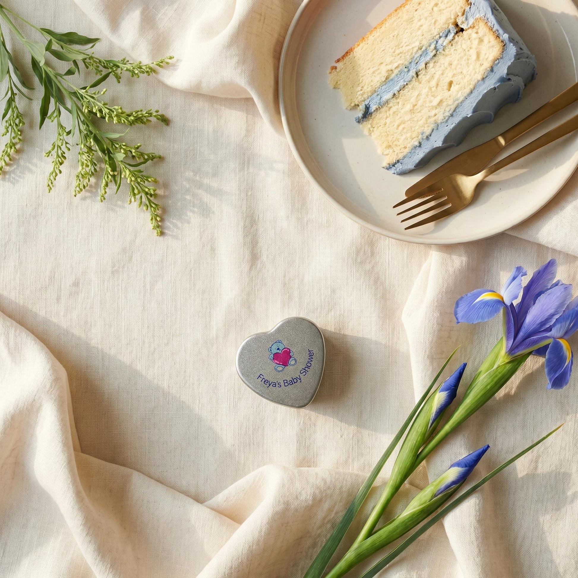 Personalised blue baby shower heart tin candle favour styled with blue iced cake and iris flowers — teddy bear lid design