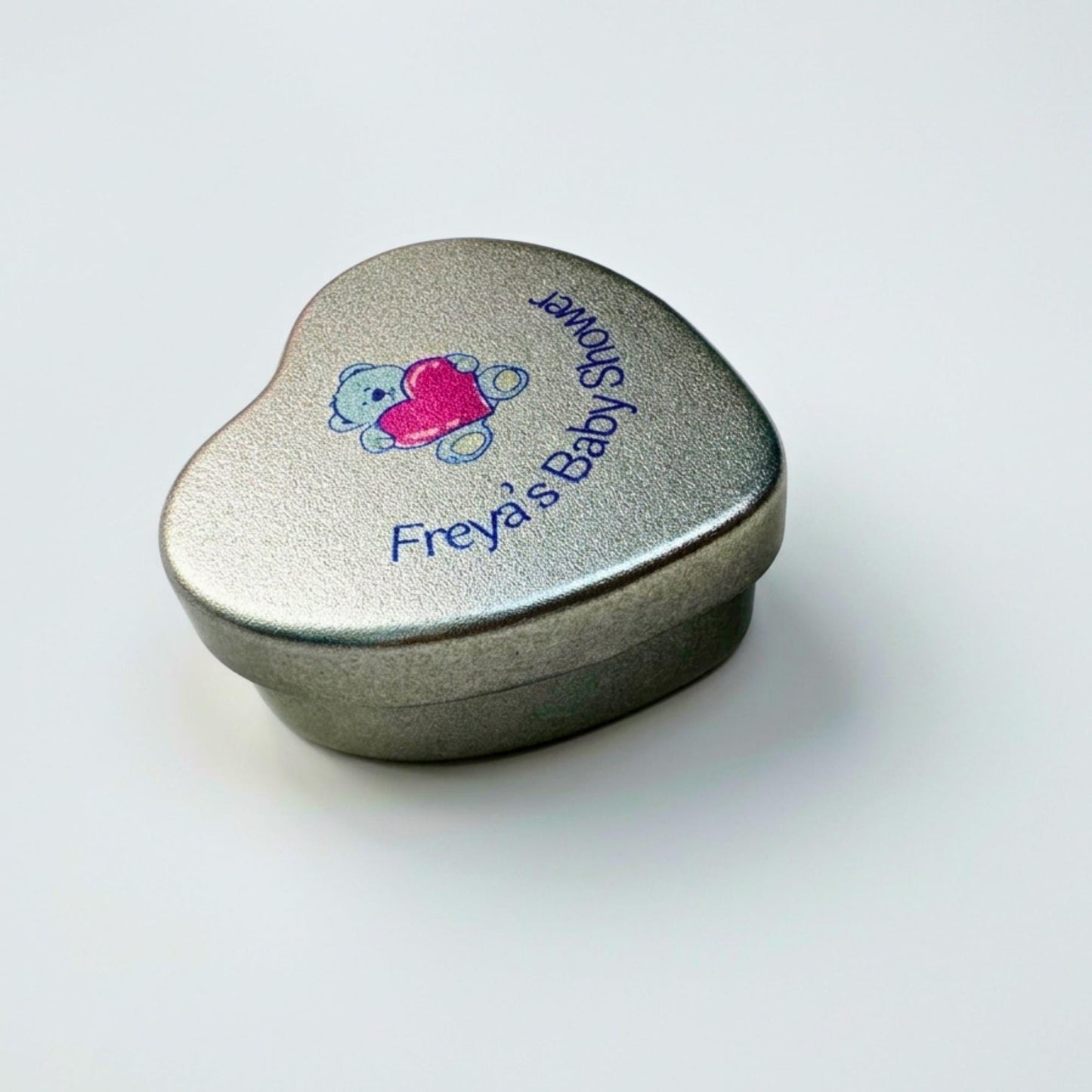 Personalised blue teddy bear baby shower heart tin candle favour — close-up side view of silver tin lid