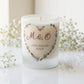 Personalised wedding candle with couple's initials and date in a boho floral heart design