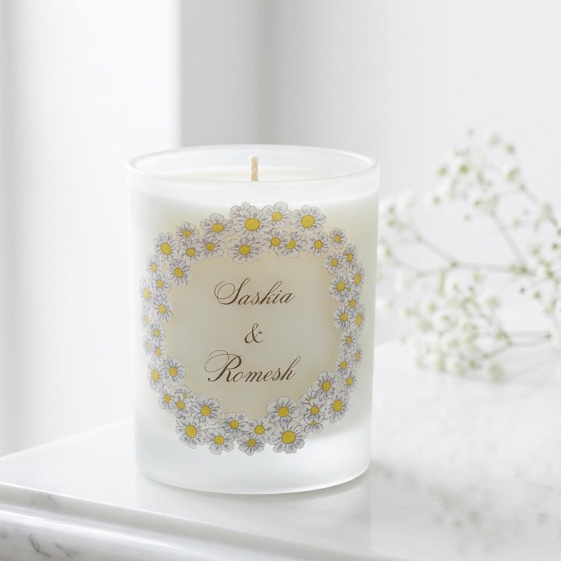 Personalised wedding candle with names and date in a hand-drawn daisy design on frosted glass