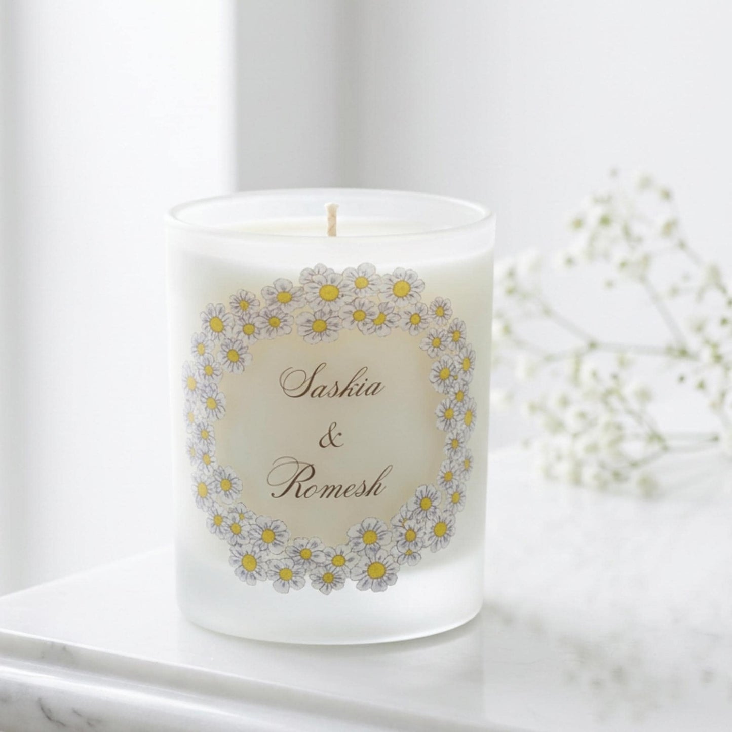 Personalised engagement candle with couple's names in a hand-drawn daisy design on frosted glass