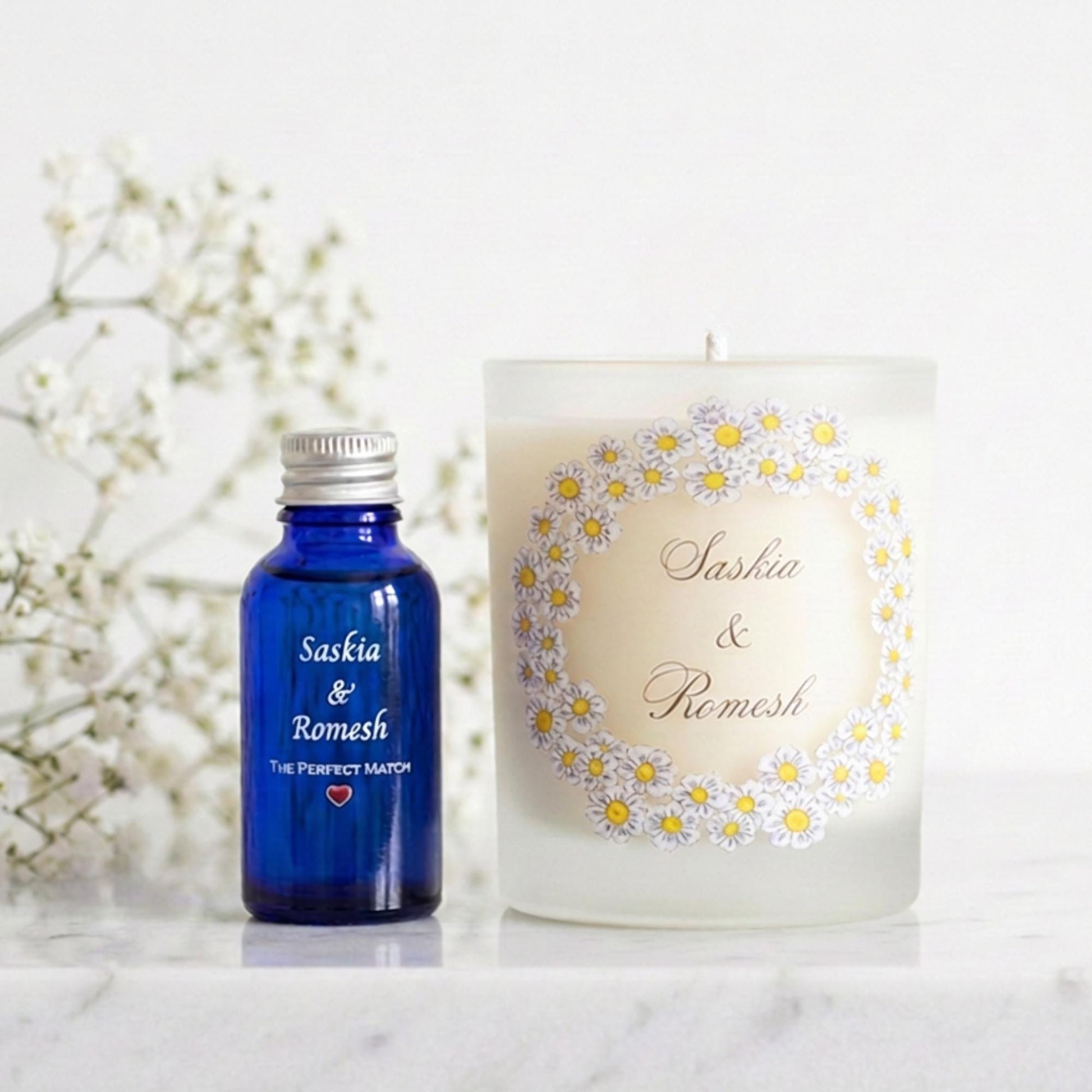 Personalised engagement candle with couple's names in a hand-drawn daisy design on frosted glass