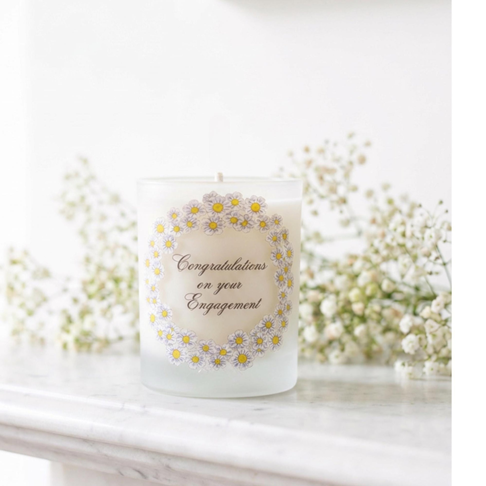 Personalised engagement candle with couple's names in a hand-drawn daisy design on frosted glass