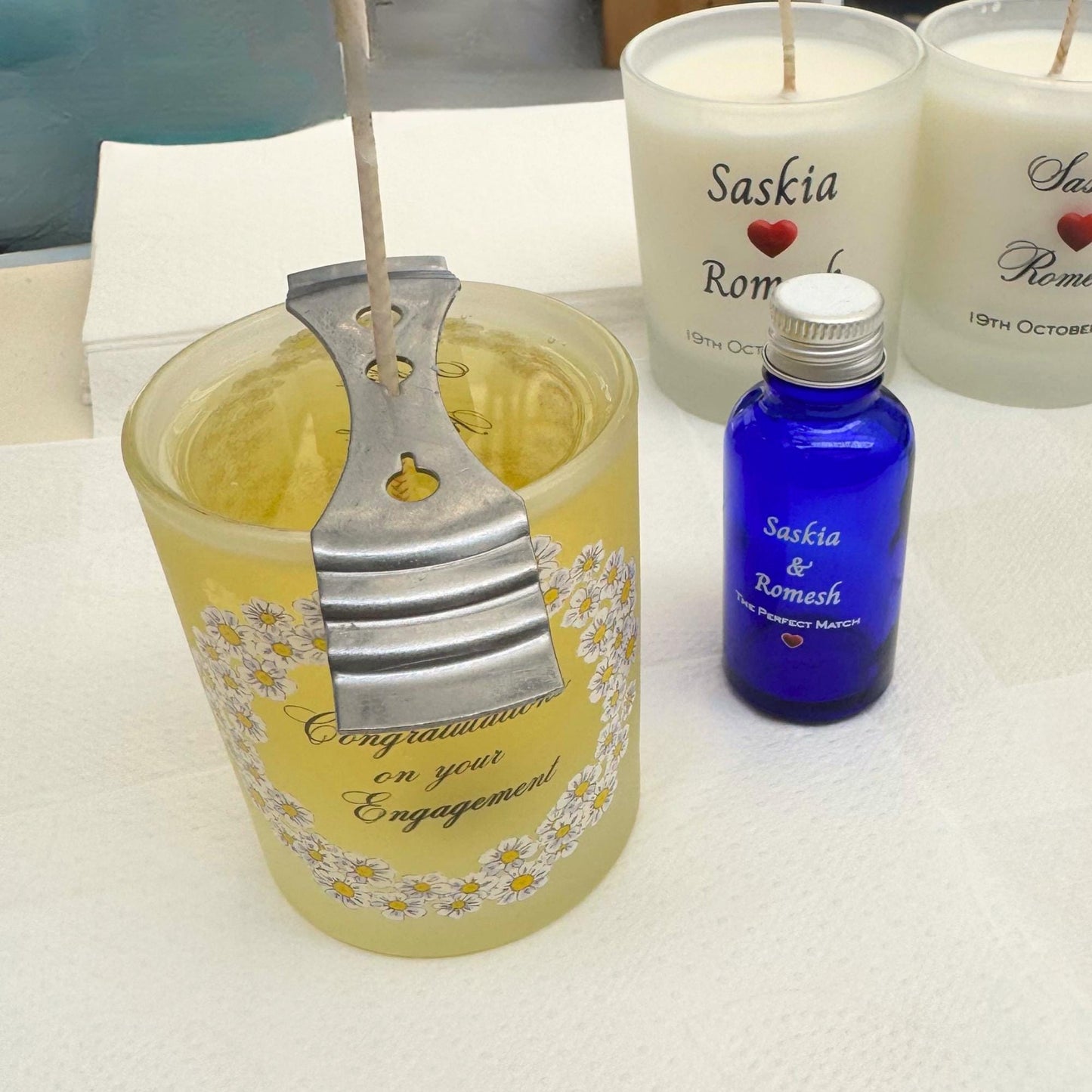 Personalised engagement candle with couple's names in a hand-drawn daisy design on frosted glass
