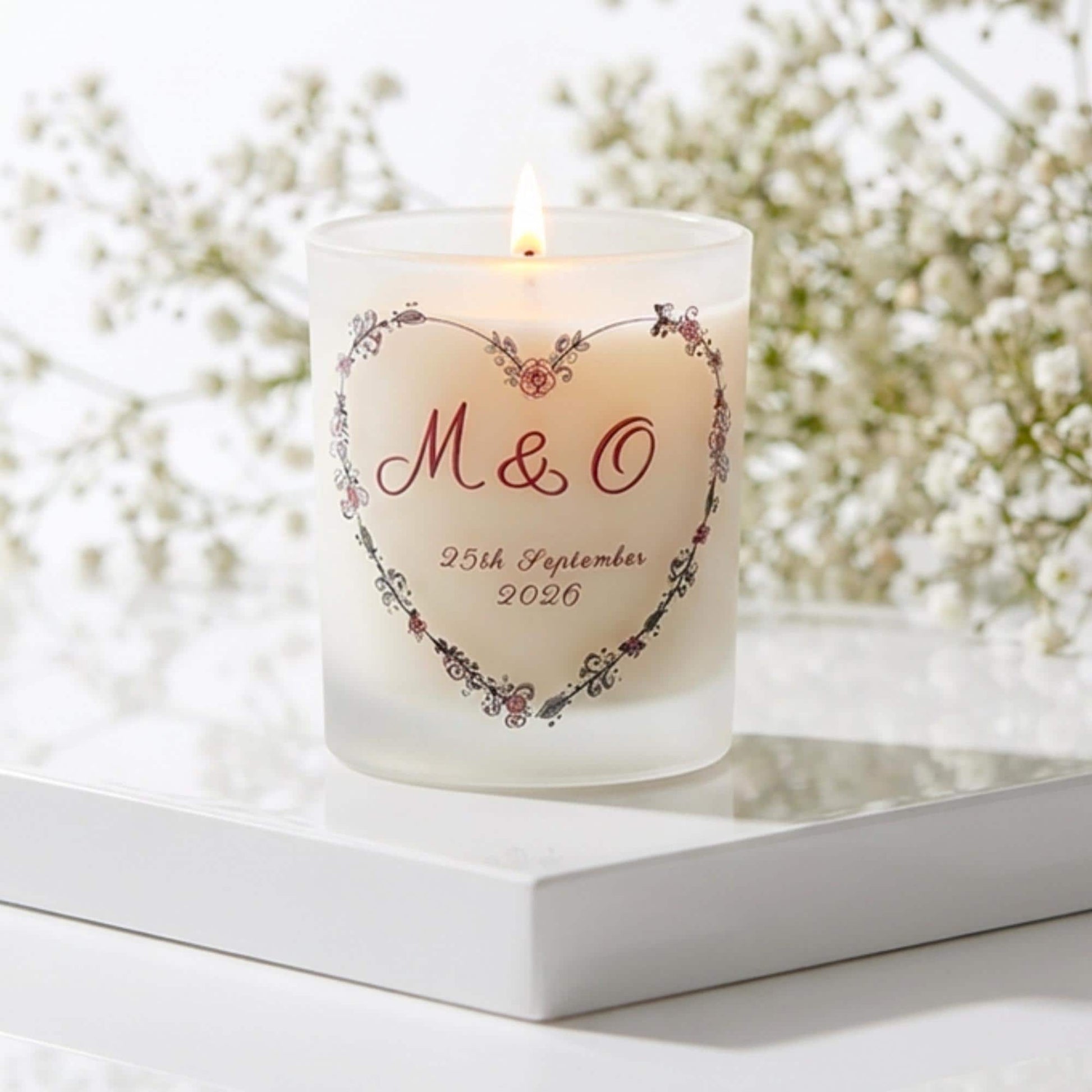 Personalised wedding candle with couple's initials and date in a boho floral heart design